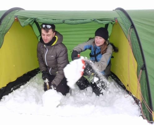 Voortent uitscheppen met sneeuw