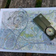 Kaart en kompas navigatie workshop_24 Ontdek de avonturier in jezelf met onze gedetailleerde kaarten! Deze kaarten tonen diverse wegen, gebouwen en groene gebieden. Gebruik onze doorzichtige kaarthoekmeter en het robuuste groene kompas met draagkoord voor perfecte navigatie tijdens jouw volgende avontuur.