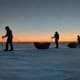 Greenland Expedition: 300 Km Reached in Icy Cold 3 Gestructureerde sleeptochten onder een kleurrijke zonsondergang in de ijswoestijn.