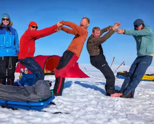Mensen die samen plezier hebben tijdens een outdoor workshop in de sneeuw op Arctic Adventure.