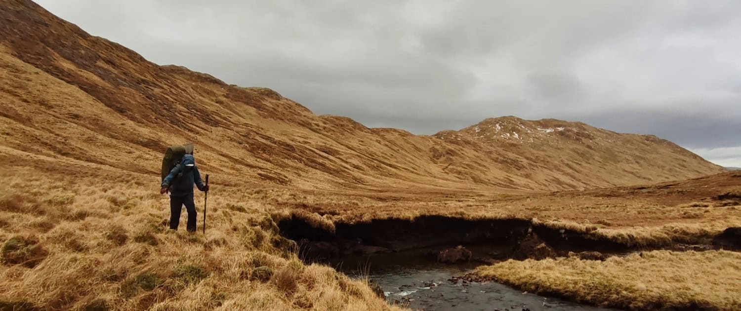 Wandelaar in de natuur, bergachtig landschap, ruige heuvels, wandelvriend, outdoor avontuur, Noord-Europa, herfst, natuurwandeling.