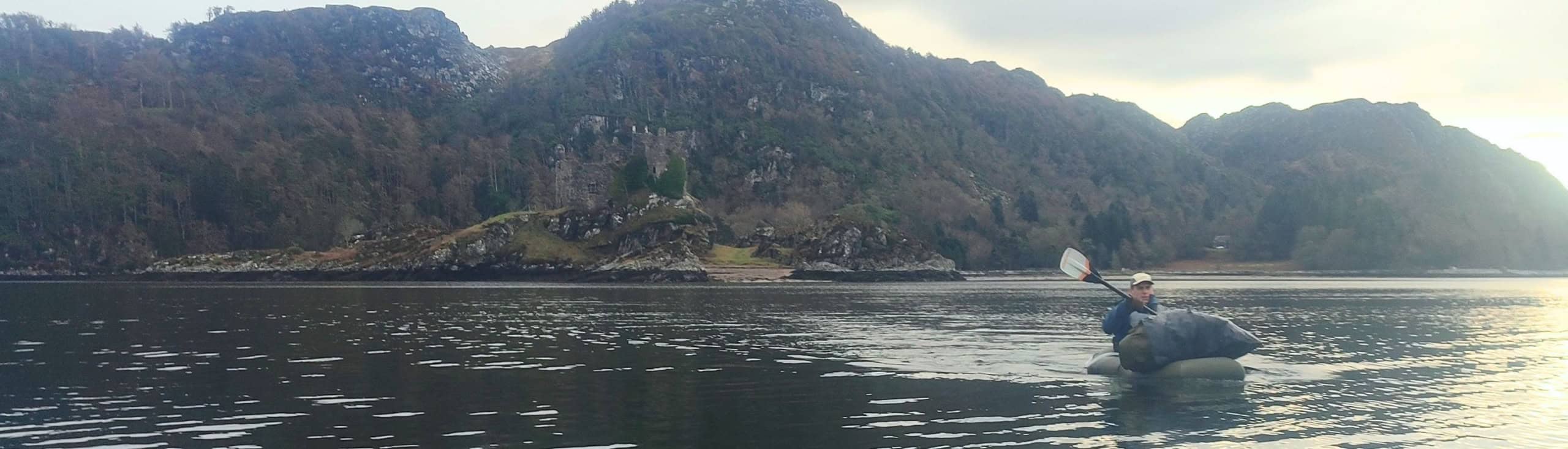 Natuurwandelen in fjordlandschap met kayak op het water.