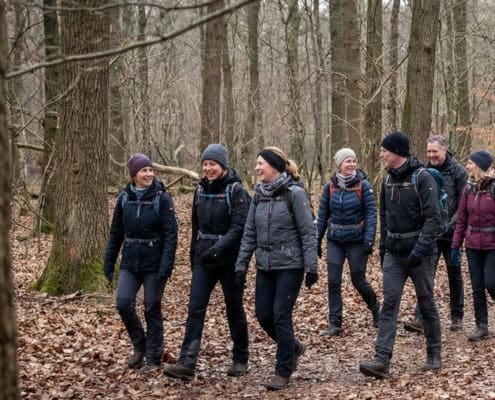 People hiking in a forest in autumn, dressed in outdoor clothing and having fun.